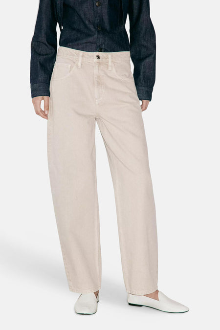 Beige 5-pocket broek van MANGO, rechte pasvorm, lichte denimtextuur, gedragen met donkerblauw overhemd en witte loafers, front view.