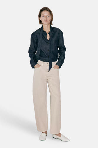 Beige 5-pocket broek van MANGO, rechte pasvorm, lichte stof, model met donkerblauw overhemd en witte loafers, front view