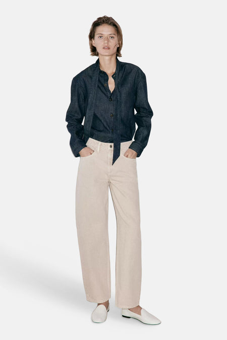 Beige 5-pocket broek van MANGO, rechte pasvorm, lichte stof, model met donkerblauw overhemd en witte loafers, front view