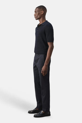 Blauwe chino's van MANGO, zijprofiel, gestreept overhemd, zwarte loafers, strakke pasvorm