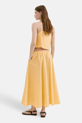 Gele casual rok van MANGO, achterzijde, met elastische taille en zakken, model draagt bijpassende top en zwarte sandalen