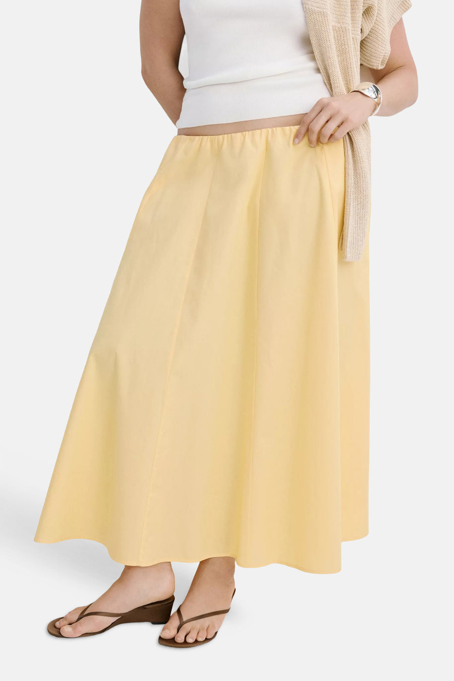 Gele casual rok van MANGO, met elastische taille en vloeiende A-linie, gedragen met wit topje en bruine sandalen, front view