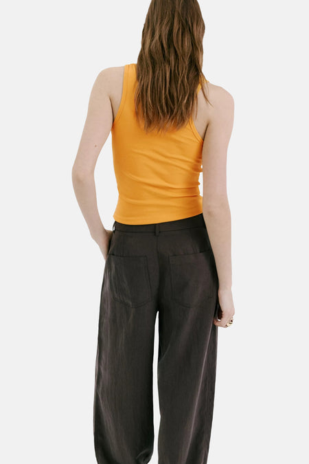 Oranje tanktop van MANGO, achterkant weergegeven, strakke pasvorm, gedragen met donkere wijde broek