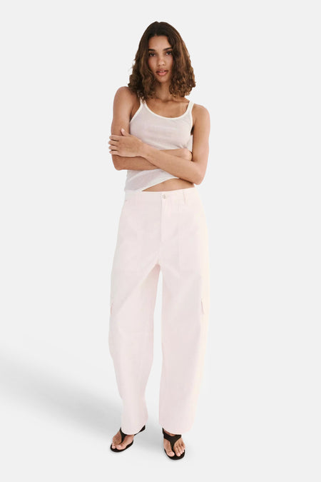 Roze cargobroek van MANGO, lichte stof, wijde pasvorm, voorzijde met zakken, model in full length pose met wit topje en sandalen