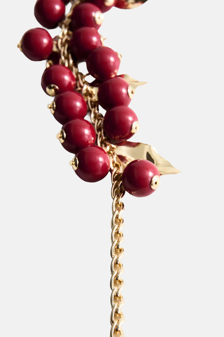 Korte multicolor halsketting met rode kralen en gouden ketting van MANGO, versierd met bladaccenten, close-up weergave
