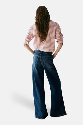 Multicolor gestreept overhemd met lange mouwen van MANGO, achterzijde weergegeven, geruchte mouwen, geknoopt in de taille, gecombineerd met donkerblauwe wijde jeans.