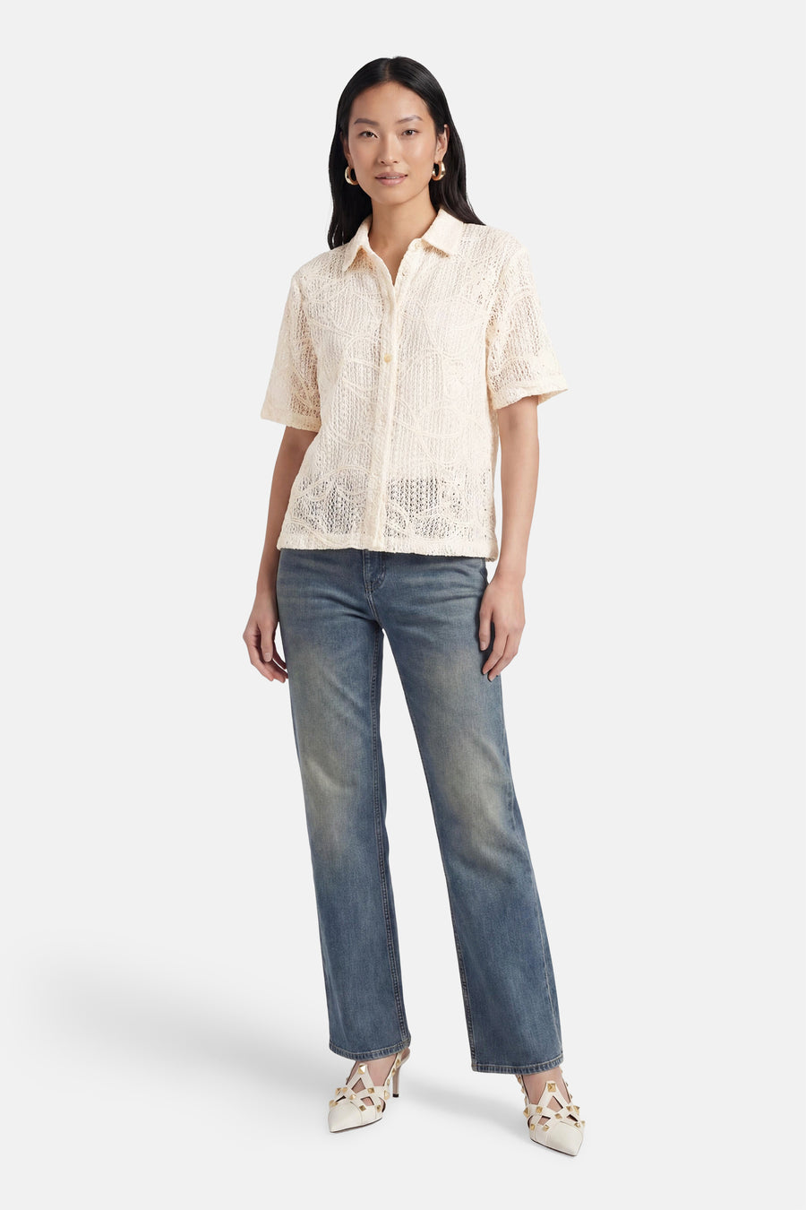Beige blouse met korte mouwen van Terra di Siena, met open gebreid patroon, gedragen met jeans en pumps.
