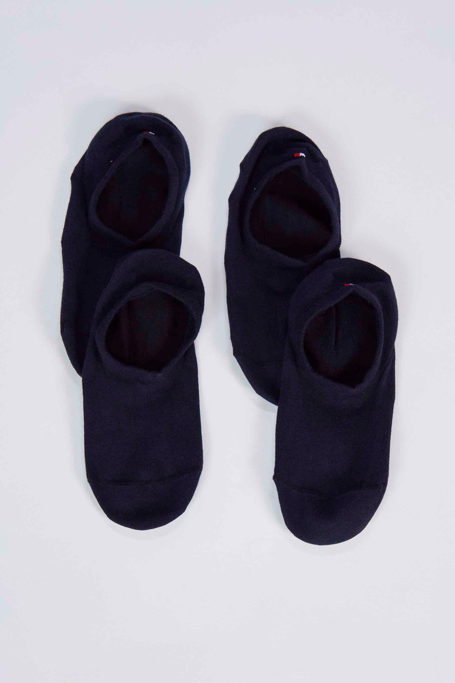 Donkerblauwe sokken van TOMMY JEANS met een klein vlagdetail aan de rand, liggend op een witte achtergrond.