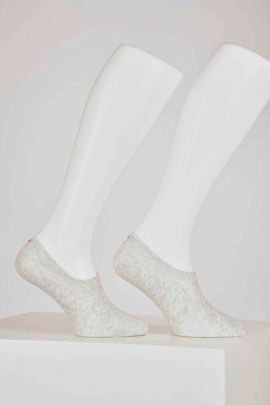 Grijze sokken van TOMMY JEANS, gedragen op witte mannequinvoeten, staand op een witte ondergrond.
