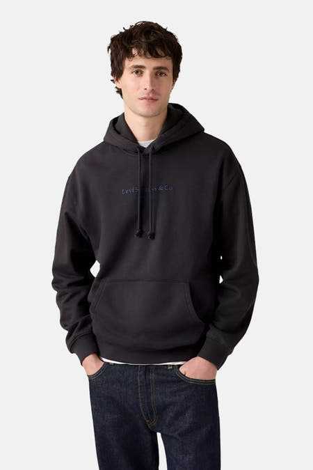 Grijze sweater met kap van Levi's, met trekkoorden en buidelzak, gecombineerd met een donkerblauwe jeans.