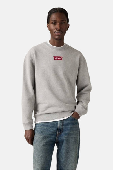 Pull gris de Levi's, avec des manches longues et un petit logo rouge sur la poitrine.