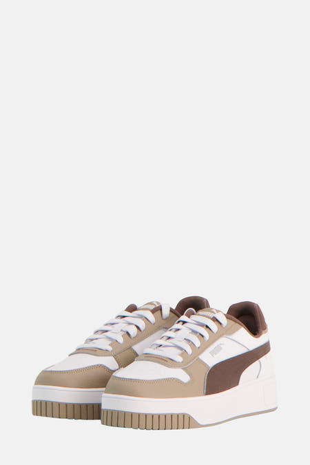 Bruine sneakers van PUMA met witte veters en een witte zool.
