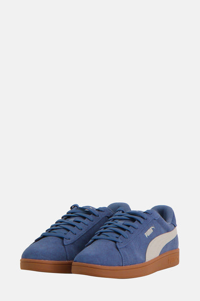 Sneakers bleus de PUMA, avec une semelle brune à motif croisé.
