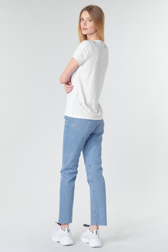 Wit T-shirt van Levi's, met korte mouwen en gedragen met een spijkerbroek en witte sneakers.
