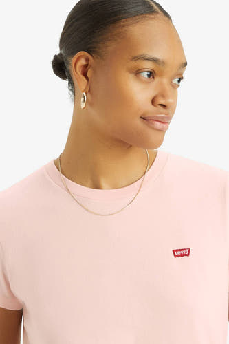 T-shirt rose à manches courtes de Levi's, avec un petit patch logo rouge, associé à une chaîne dorée et des boucles d'oreilles.