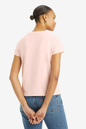 T-shirt rose à manches courtes de Levi's, vu de dos, avec des jeans et des boucles d'oreilles en or.