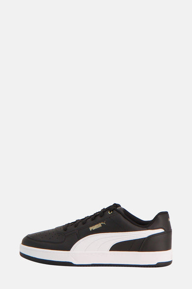 Zwarte sneakers van PUMA, met een witte streep aan de zijkant en een zwarte zoolrand.
