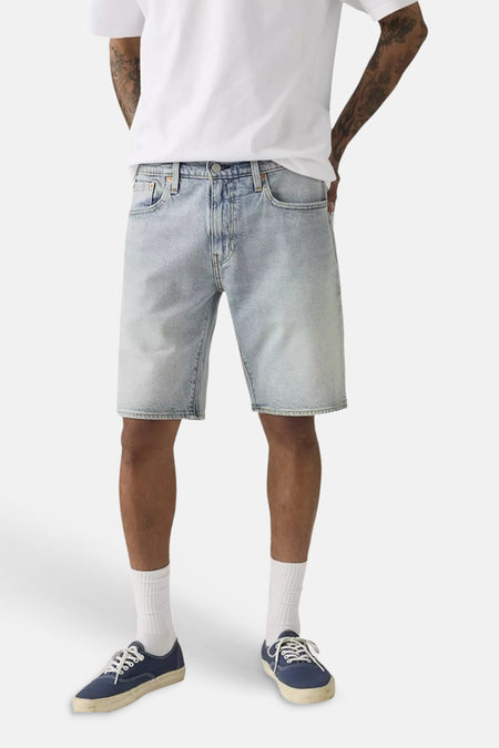 Lichtblauwe denim shorts van Levi's® met gewassen look, klassieke vijfzakkenstijl, gedragen met wit T-shirt en blauwe sneakers.