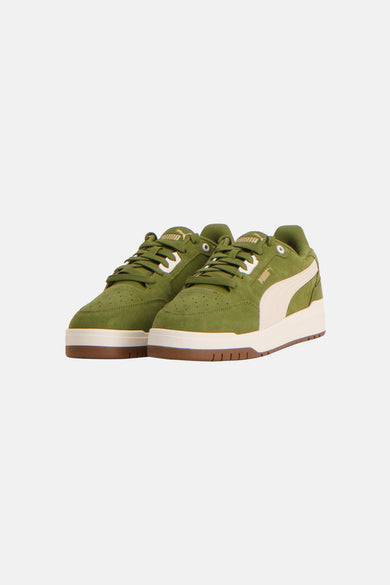 Groene sneakers van PUMA met witte details en een bruine zool.