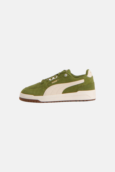 Groene sneakers van PUMA, met een crèmekleurige streep en een bruine zool.