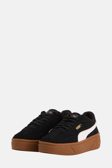 Zwarte sneakers van PUMA, met witte streep en bruine zool.