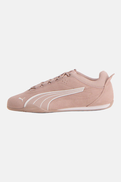 Baskets roses de PUMA, avec des détails de rayures blanches et un logo subtil sur le côté, en vue latérale.