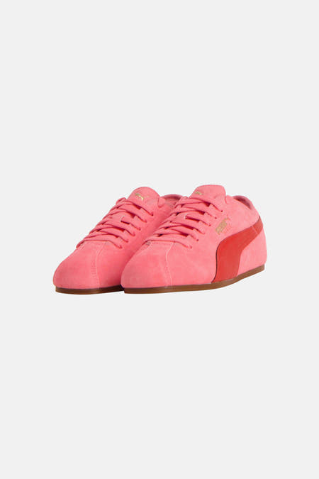 Sneakers roses de PUMA, vus de l'arrière, avec une texture en suède et des détails rouges.