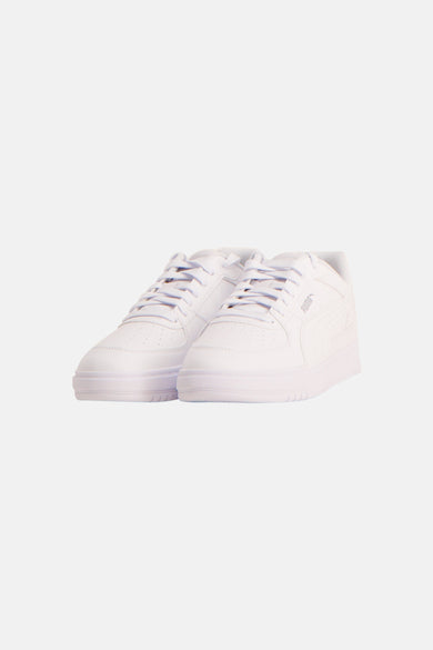 Witte sneakers van PUMA, met vetersluiting en een subtiel geperforeerd patroon.
