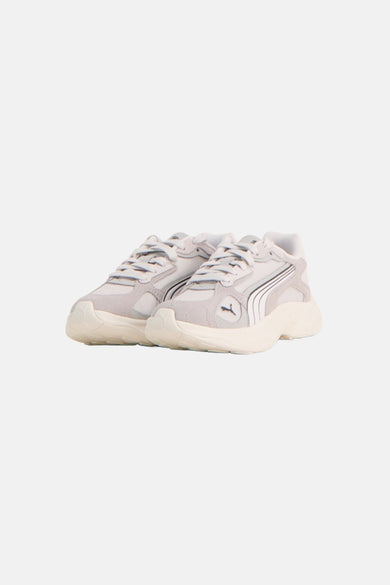 Grijze sneakers van PUMA met mesh en suède-achtige details, crèmekleurige zool en iconische witte formstrip.