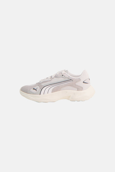 Grijze sneakers van PUMA met witte Formstrip, crèmekleurige chunky zool en mesh details, zijaanzicht.