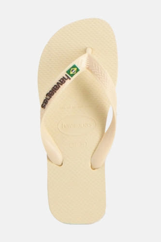 Beige slippers van Havaianas, met een textuur op het voetbed en de merknaam op het bandje met Braziliaanse vlag.
