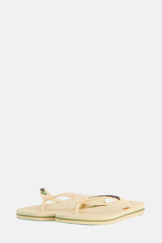 Beige slippers van Havaianas, met groene en bruine accenten langs de zool.
