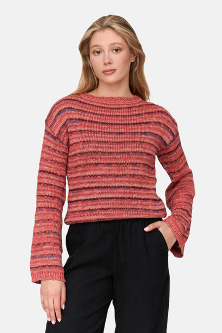 Roze trui met ronde hals van 24 colours gmbh, met een gestreept patroon en gedragen met een zwarte broek.