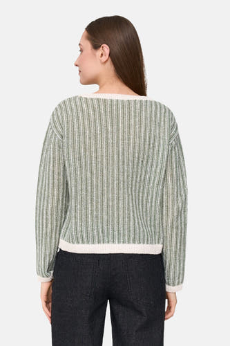 T-shirt vert avec col rond de 24 Colleurs, motif rayé, porté avec un pantalon foncé.