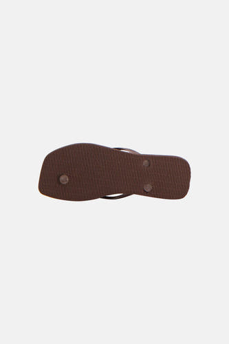 Bruine slippers van Havaianas met geribbelde zool, schuin van onderen gefotografeerd.