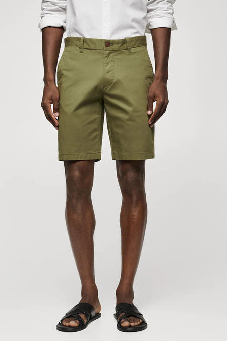 Beige short van MANGO, gedragen met een wit overhemd en zwarte sandalen.