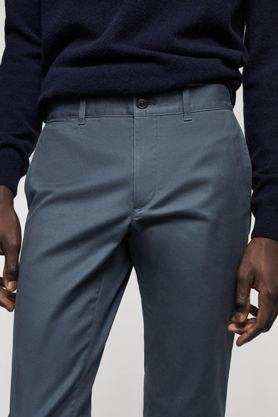 Blauwe broek van MANGO, zichtbaar met knoopsluiting en steekzakken.