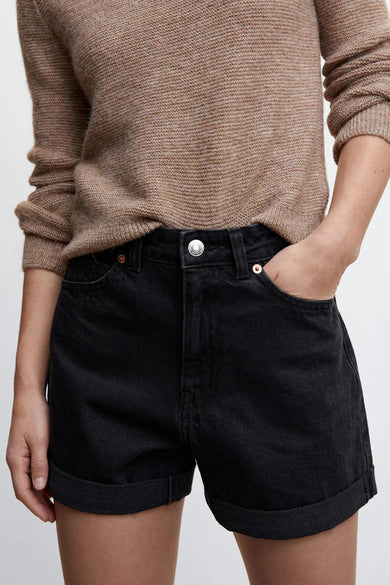 Zwarte 5-pocket shorts van MANGO, met opgerolde pijpen en zilveren knoop, gedragen met een beige trui, front view.