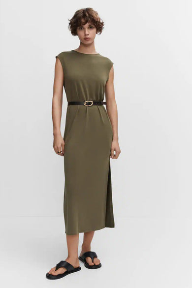 Robe longue beige sans manches de MANGO, avec col rond et fente latérale, stylisée avec une ceinture noire et des sandales