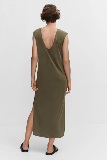 Robe beige clair de MANGO, dos avec un profond décolleté en V et fente latérale, tissu lisse, modèle portant des tongs noires