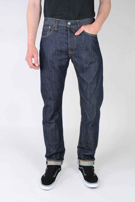 Donkerblauwe straight jeans van Levi's, met lichte wassing en omgeslagen pijpen, gecombineerd met zwarte sneakers.
