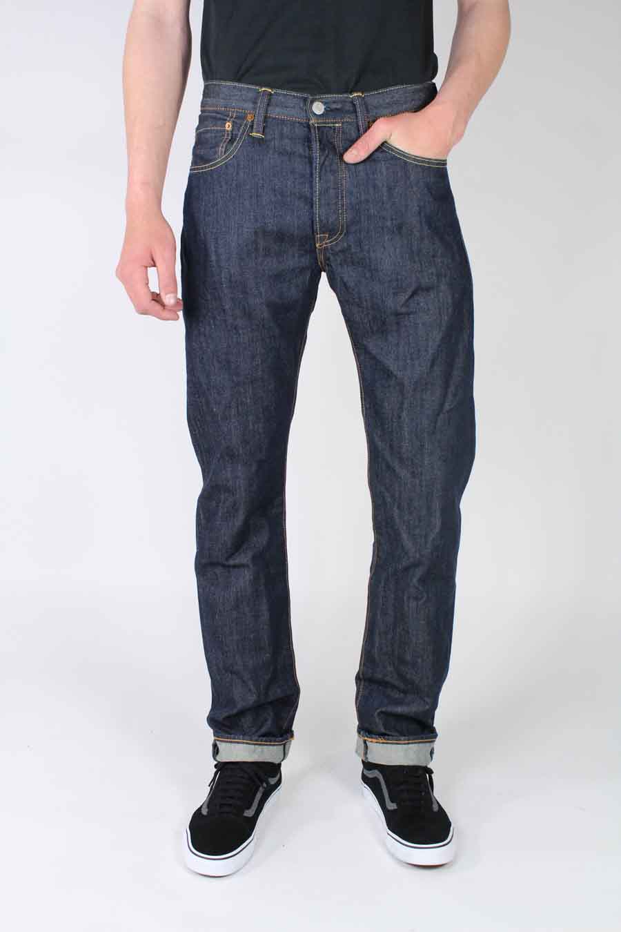 Donkerblauwe straight jeans van Levi's, met lichte wassing en omgeslagen pijpen, gecombineerd met zwarte sneakers.

