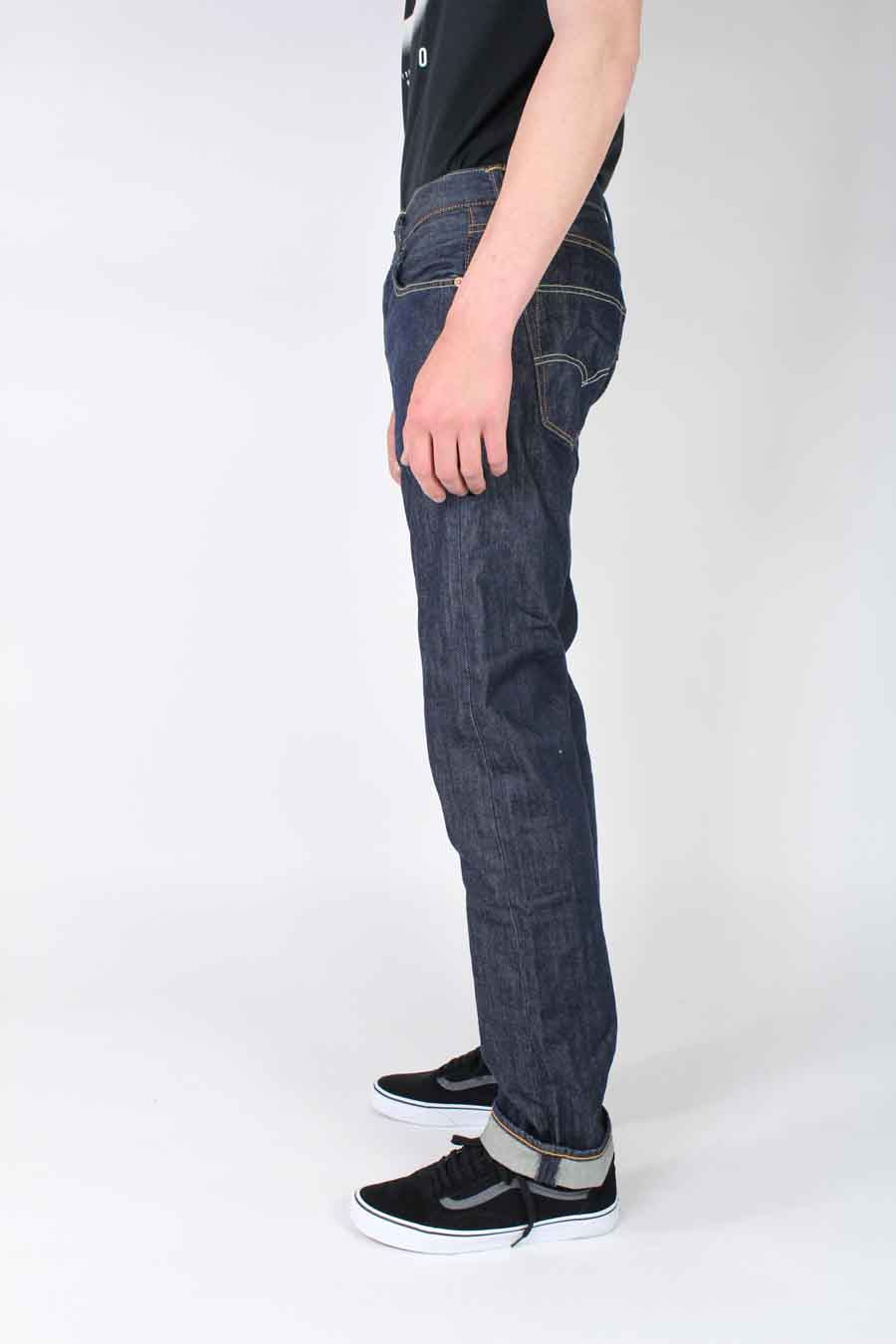 Donkerblauwe rechte jeans van Levi's®, met opgerolde pijpen en gedragen met zwarte schoenen.