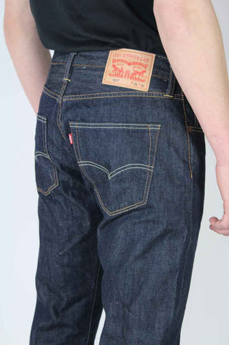 Donkerblauwe straight jeans van Levi's, met zichtbaar rood merklabel op de achterzak en lederen patch op de tailleband.