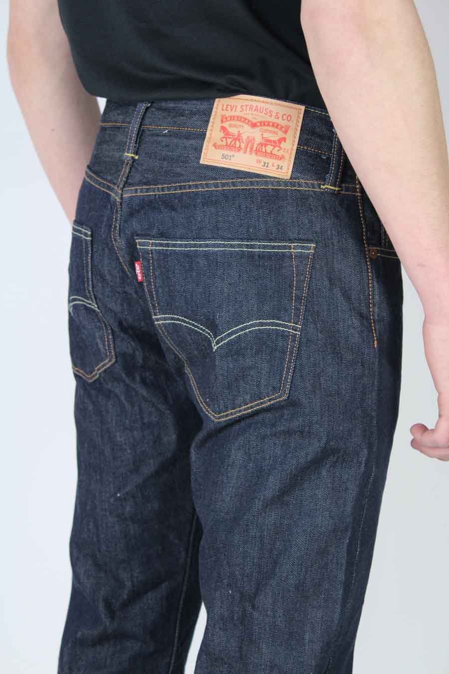Donkerblauwe straight jeans van Levi's, met zichtbaar rood merklabel op de achterzak en lederen patch op de tailleband.