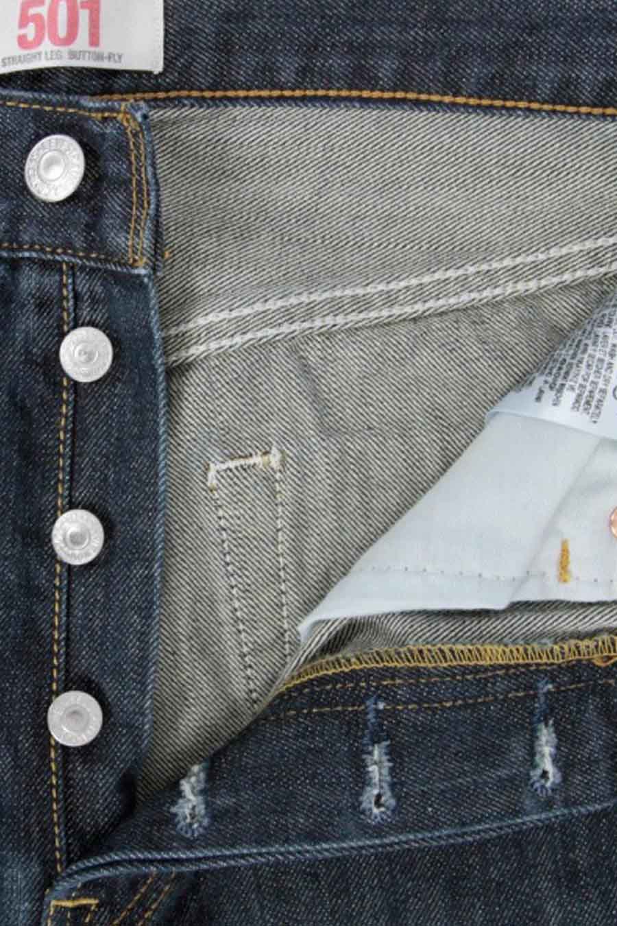 Donkerblauwe straight jeans van Levi's, met knoopsluiting en kenmerkende stiksels, cropped close-up.
