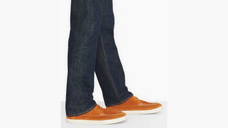 Donkerblauwe jeans straight van Levi's®, gedragen met bruine mocassins met witte zool en stiksels, in zijaanzicht.