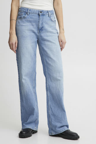 Lichtblauwe wide jeans van Pulz, gecombineerd met zwarte schoenen, en met een tattoo op de arm.
