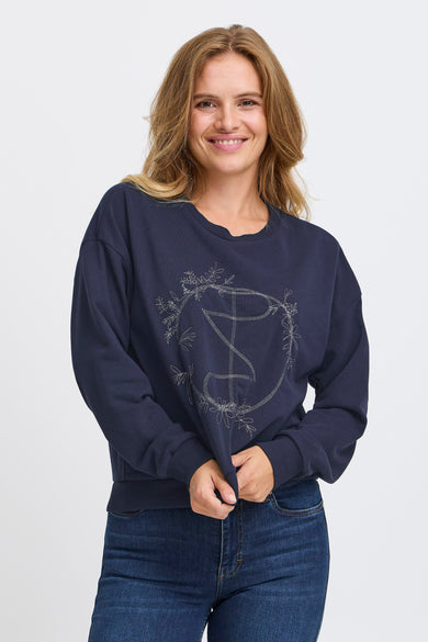 Blauwe sweater van PULZ, met een ronde hals en een decoratieve print met bloemmotieven.
