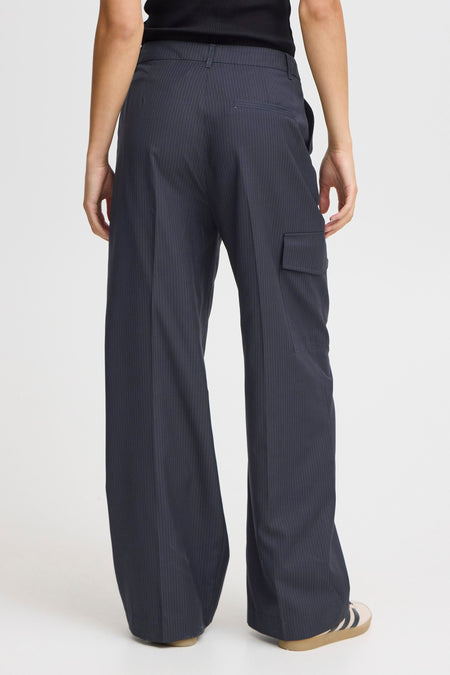 Pantalon bleu de PULZ, avec une rayure blanche et un cargo, vu de derrière.